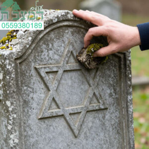 יד מסירה טחב ממצבה עתיקה כחלק מתהליך מקצועי של חידוש וניקוי מצבות